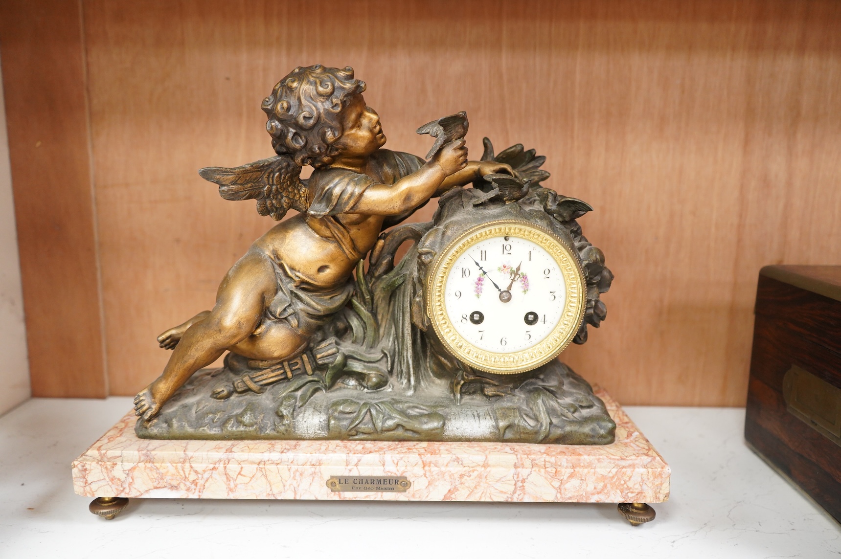 After Georges Maxim (French, 1885-1940), ‘Le Charmeur’, an early 20th century gilt spelter and rouge marble mantel clock, 39cm wide